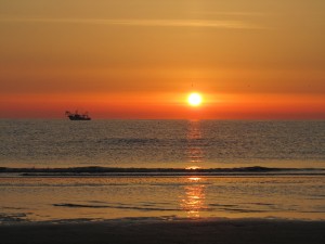 Восходящее солнце из моря, пляж в Римини, Эмилья-Романья, Италия.